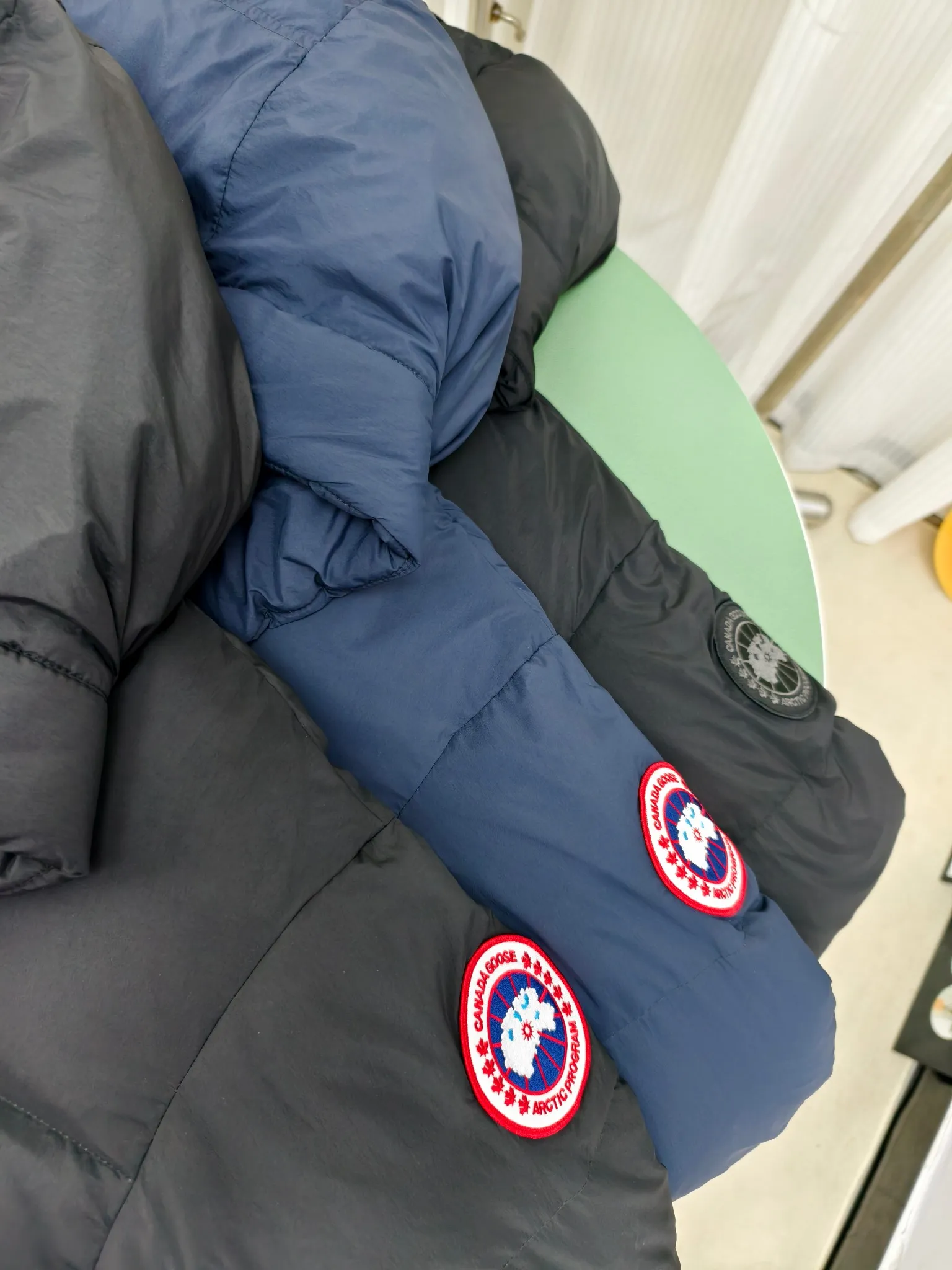 P940 Canada Goose Lawrence Down Jacket The Lawrence Down Jacket provides essential protection for everyday adventures and is made from sustainable Enduraluxe fabric with a durable soft touch. It features a quilted body, an adjustable down hood and a longer hem. Adjustable, down-filled, communicated hood. Two-way center front zipper increases range of motion and ventilation. The chin-protecting suede knit stand-up collar is soft and extra-comfortable. Inset rib-knit cuffs for added comfort and locked in heat. CORDURAD piping at the cuffs hem and reflective double-stripe grip tape at the back. Internal shoulder strap Color: black with red label black with black label azure blue Size: XS-2XL